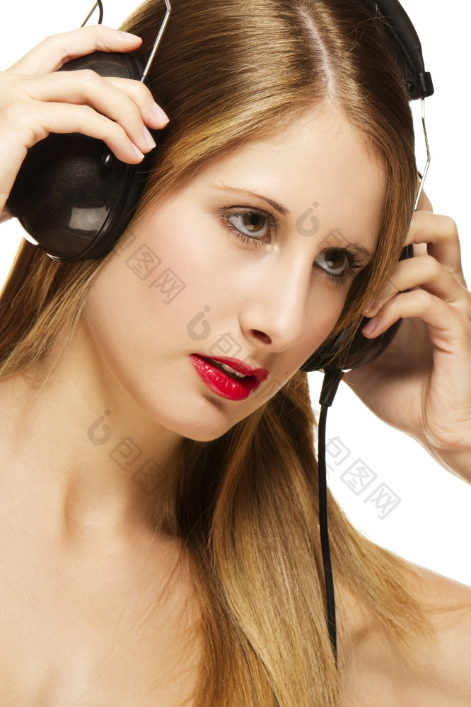 年轻的金发女郎女人与耳机听音乐年轻的美丽的金发女郎女人与耳机听音乐