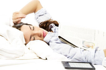 女人感觉睡着了下报纸与电子书读者一边女人感觉睡着了下报纸与电子书读者一边白色背景