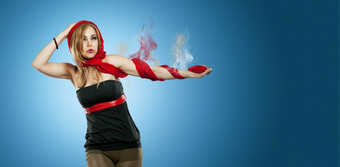 美丽的女人与红色的围巾前面蓝色的背景而且吸烟手臂美丽的女人与吸烟手臂