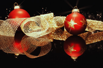 红色的圣诞节球与金金属丝带红色的圣诞节球与闪闪发光的星星与金金属丝带黑色的镜子
