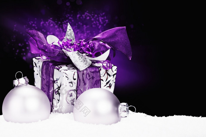 紫色的圣诞节现在雪紫色的圣诞节现在雪与圣诞节球而且紫色的闪电黑色的背景