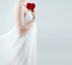 华丽的女人白色褶皱持有红色的心她的肩膀