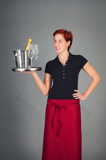 女服务员服务香槟快乐年轻的女服务员服务香槟托盘
