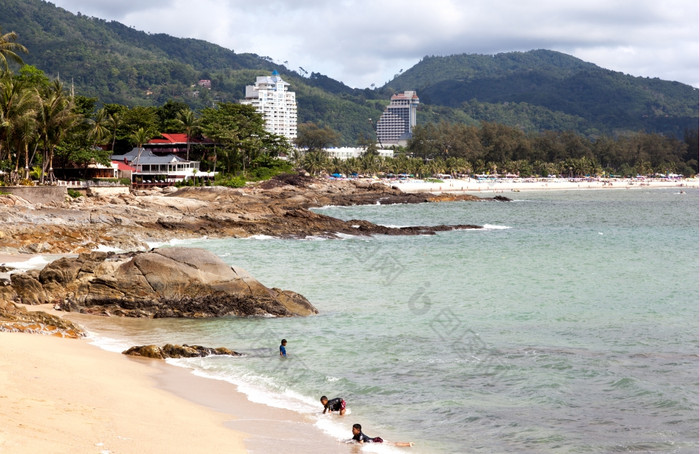 泰国孩子们是游泳的野生海滩的背景芭东海滩海滩而且现代酒店编辑只有