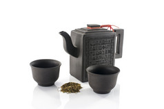 亚洲茶壶而且两个杯与新鲜的干燥茶孤立的白色