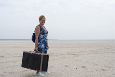 女人与老古董使用手提箱走的海滩
