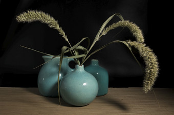三个蓝色的花瓶仍然生活木表格与小麦玉米黑色的背景三个蓝色的花瓶仍然生活木表格