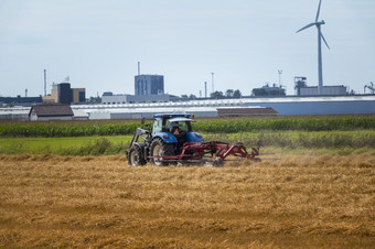 网状蚜虫荷兰8月-农民拖拉机切割有农场场网状蚜虫村荷兰与的温室背景和的行业附近鹿特丹农民拖拉机切割有农场场网状蚜虫