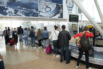 olbia萨迪尼4月-人等待为他们的手提箱的机场奥尔比的意大利岛撒丁岛人等待为的手提箱机场