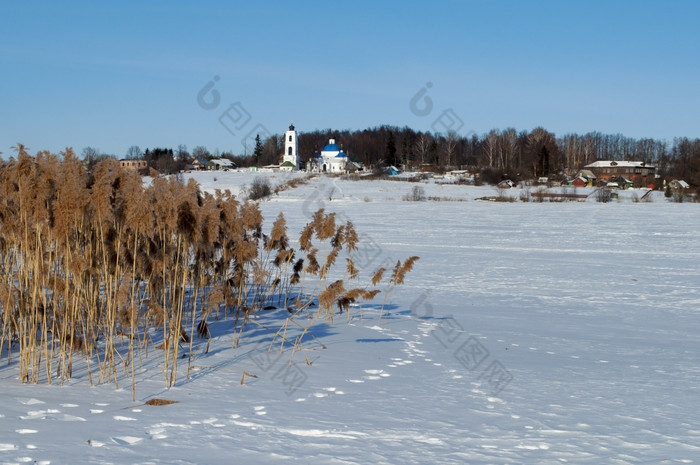 冬天农村景观与冻河而且干已经的海岸阳光明媚的一天