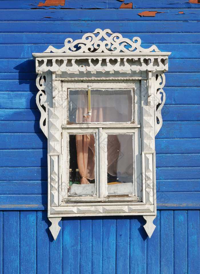 白色窗口与雕刻点缀蓝色的木墙Tutaev俄罗斯