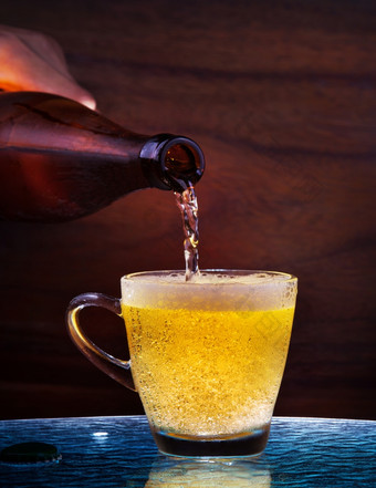 层啤酒排水从瓶玻璃表格与木背景使用为酒精喝饮料成人酒吧酒吧而且餐厅