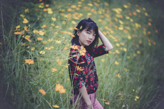 肖像亚洲年轻的女人模型构成黄色的花盛开的场