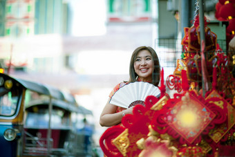 亚洲女人穿中国人传统衣服与中国人竹子<strong>风扇</strong>露出牙齿的微笑脸耀华力街中国<strong>小</strong>镇曼谷泰国