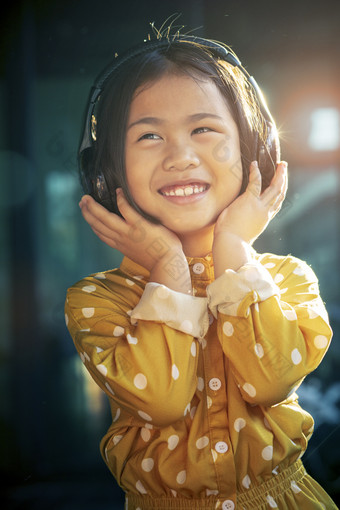 肖像亚洲<strong>孩子</strong>们听力音乐头电话露出牙齿的微笑幸福情感