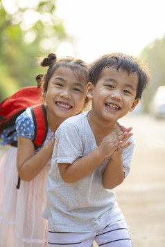 两个可爱的亚洲孩子们男孩和女孩与在开玩笑吧微笑脸