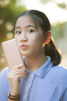 肖像脸亚洲少年幸福情感与智能手机手