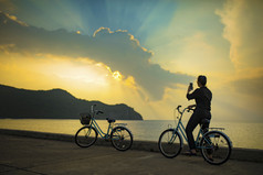 女人自行车采取照片令人惊异的太阳光天空