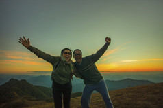 亚洲旅行男人。和女人幸福情感和放松徒步旅行前山对太阳集天空