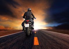 男人。骑摩托车高速公路对美丽的太阳集天空