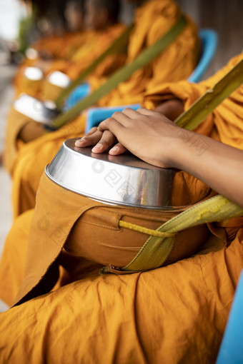 集团泰国和尚穿黄色的衣服和持有佛教碗等待为佛教人提供早....食物
