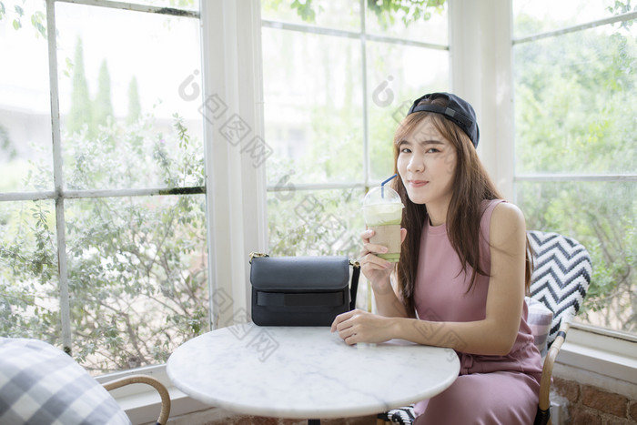 幸福微笑脸亚洲年轻的女人与很酷的瓶绿色茶饮料