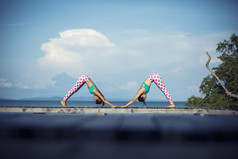 两个女人玩瑜伽构成海滩码头