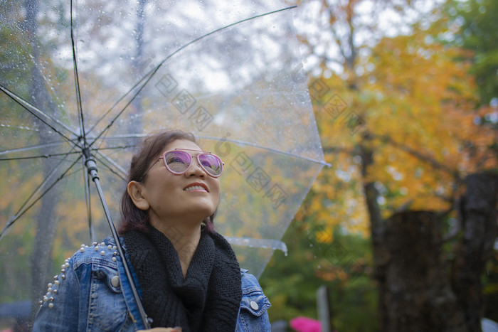 露出牙齿的微笑脸女人旅游与雨伞站秋天颜色叶子北海道日本北海道大多数受欢迎的秋天季节旅行目的地日本