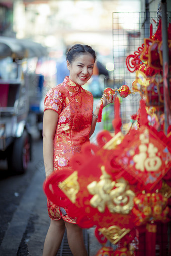 亚洲女人穿中国人传统衣服与中国人竹子风扇微笑脸耀华力街中国小镇曼谷泰国