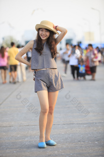 年轻的和漂亮的亚洲女人穿稻草他站和<strong>发布</strong>与拥挤的后面