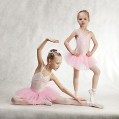 两个小女孩芭蕾舞 演员坐着的图图的地板上
