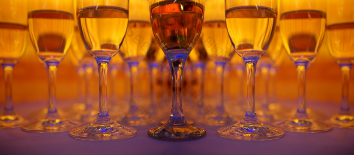很多葡萄酒杯与香槟站的色彩斑斓的背景黄色的红色的而且蓝色的颜色