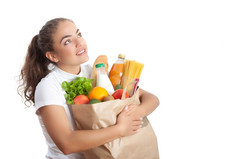 快乐年轻的女人携带购物袋完整的食品杂货白色背景