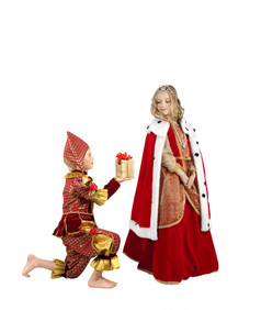 服装系列小男孩沙拉酱就像小丑站他的膝盖而且给现在的美丽的小金发碧眼的女孩穿服装女王