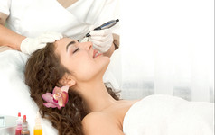 健康水疗中心特写镜头美丽的放松年轻的女人有面部按摩电解与兰花长棕色（的）头发