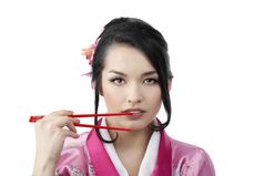 肖像的美丽的年轻的日本女人与两个双筷子穿传统的和服衣服的白色背景