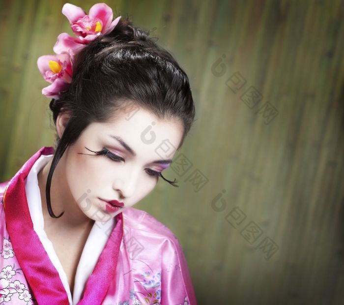 肖像的年轻的日本女人穿传统的和服衣服的绿色竹子背景