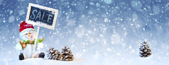 圣诞节概念可爱的雪人坐着与黑色的董事会和松视锥细胞的蓝色的和白色背景与雪