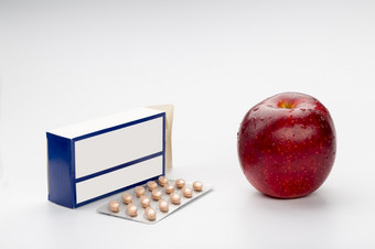药丸水泡盒子而且红色的苹果药丸盒子而且红色的苹果白色背景