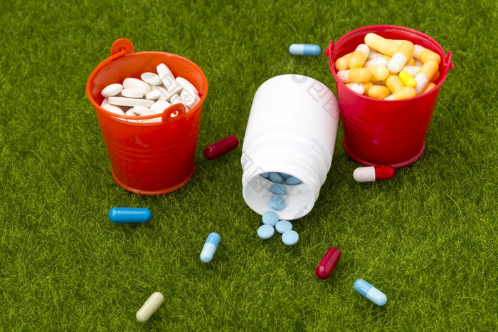 药片瓶药片和两个桶填满与药片的绿色草