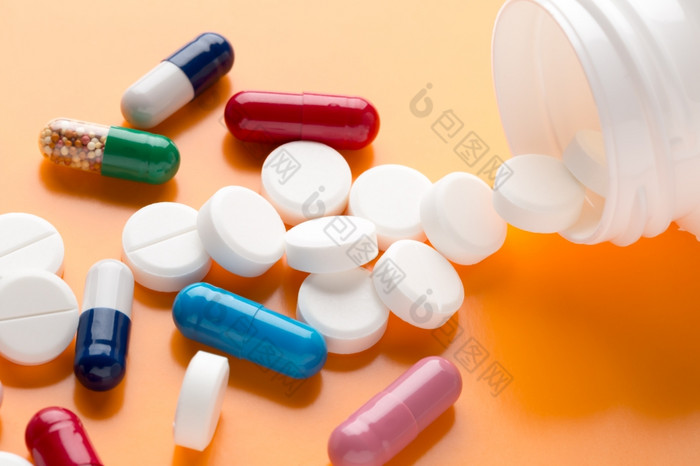 不同的五彩缤纷的药片和医学胶囊不同的五彩缤纷的药片和医学胶囊橙色背景