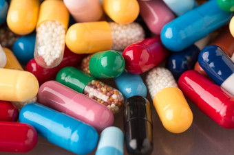 各种各样的多色药片和胶囊堆许多各种各样的多色药片和胶囊