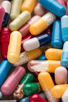 各种各样的多色药片和胶囊堆许多各种各样的多色药片和胶囊
