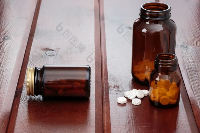 桩白色药片和玻璃瓶为药物木背景堆白色药片和玻璃瓶为药物木背景