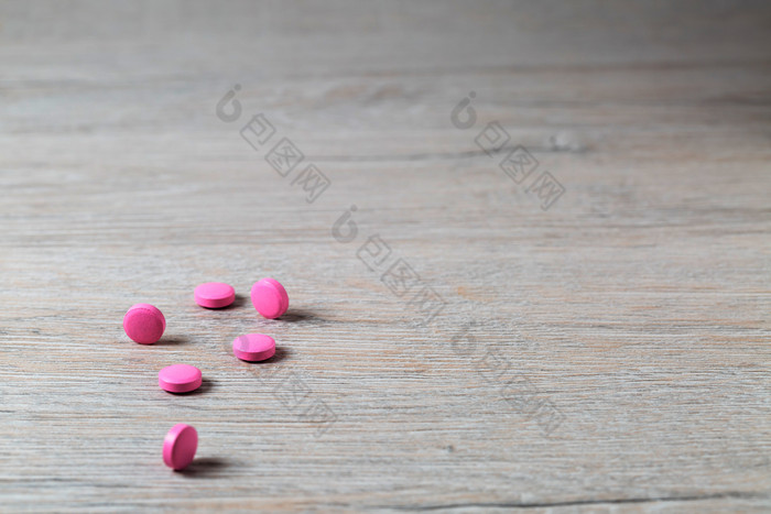 堆粉红色的轮药片明亮的表格堆粉红色的轮药片明亮的背景