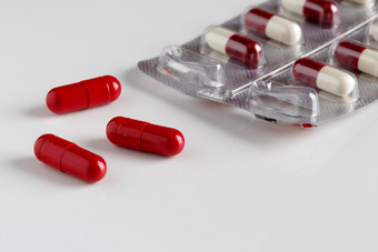 药片泡包和三个红色的胶囊药片泡包和三个红色的胶囊白色背景