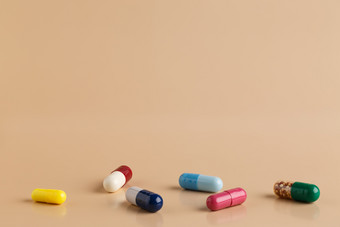 各种各样的色彩斑斓的药片和胶囊各种各样的色彩斑斓的药片和胶囊米色背景