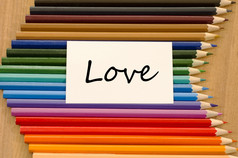 爱文本概念和彩色的铅笔木背景