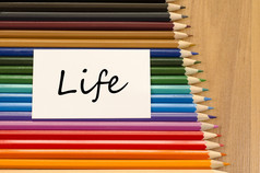 生活文本概念和彩色的铅笔木背景