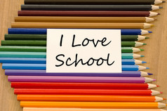 爱学校文本概念和彩色的铅笔木背景